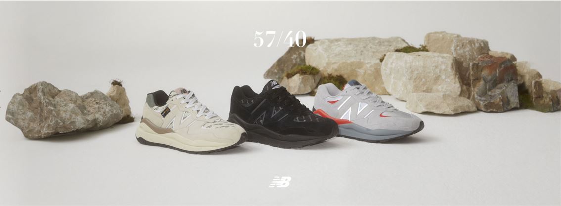 new balance - tri prave boty vedle sebe a za nimi kameny