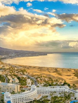 přímořské letoviště s bílými hotely a oblohou plnou oblaků