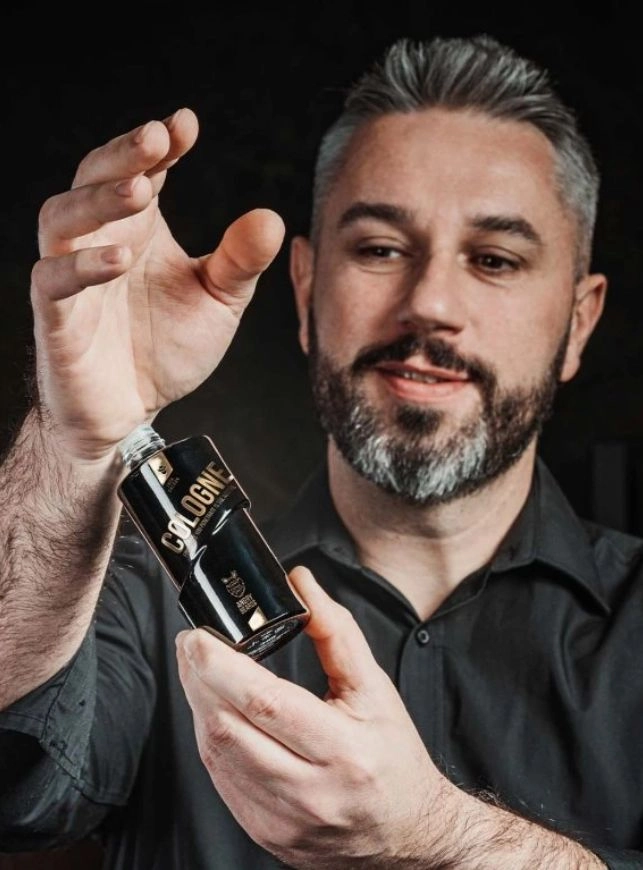 muž testuje na ruce pánský parfém v černém obalu