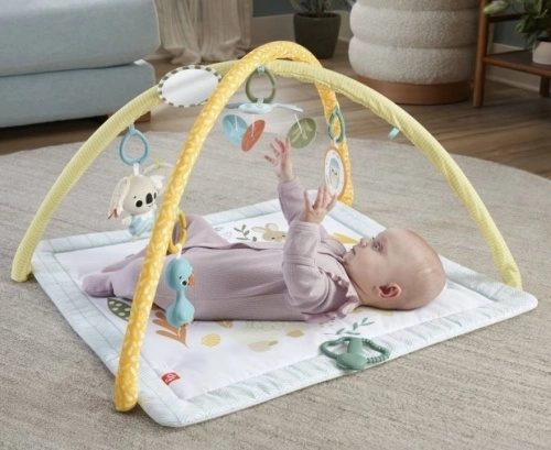 dítě ležící v obýváku na podložce s hračkami