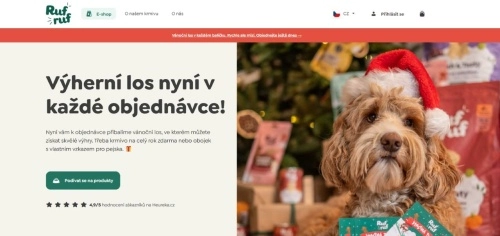 pes s vánoční čepicí u balíčků pod stromečkem