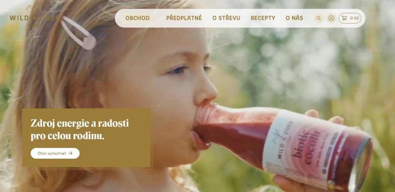 holčička pijící červenou šťávu ze skleněné láhve v přírodě