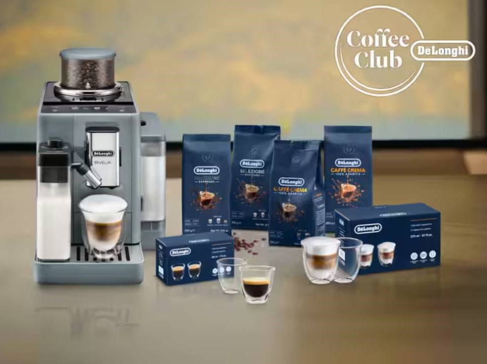 kávovar s připravenou kávou a baleními různých káv na kuchyňské lince