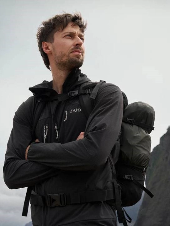 muž v mikině a s batohem na zádech na túře