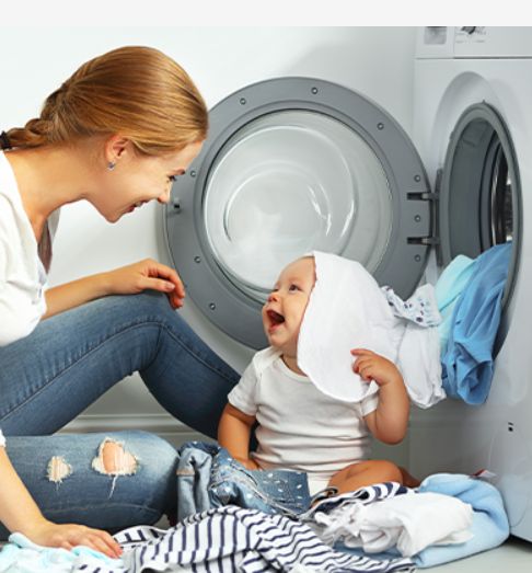 žena s dítětem u prádla při pračce