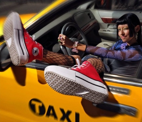 žena sedící v taxíku s červenými teniskami přes okno