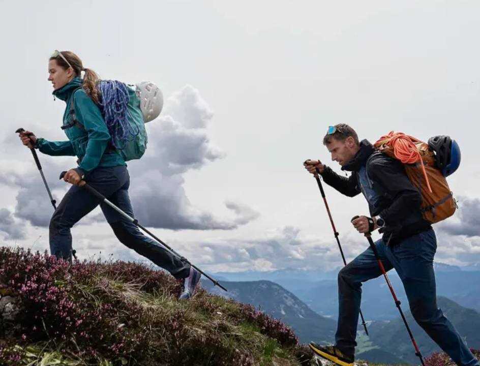 muž a žena na trekkingu na kopcích s batohy a ve sportovním oblečení