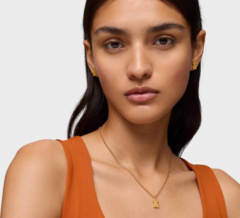 žena v oranžovém tílku s řetízkem a přívěskem na krku