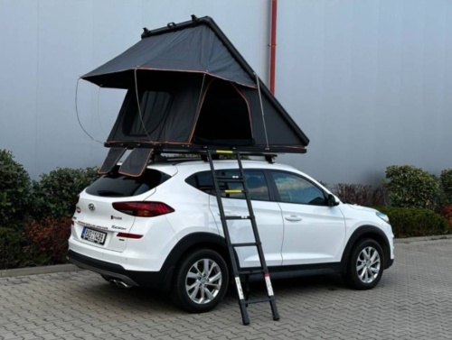 Filson Store - bílé auto na parkovišti u budovy se stanem na střeše