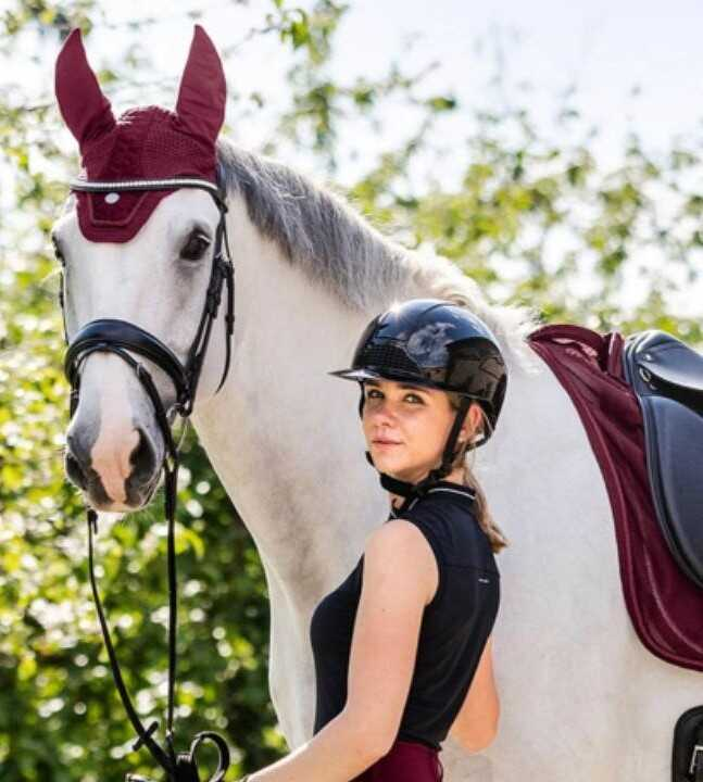 žena v jezdeckém oděvu s koněm