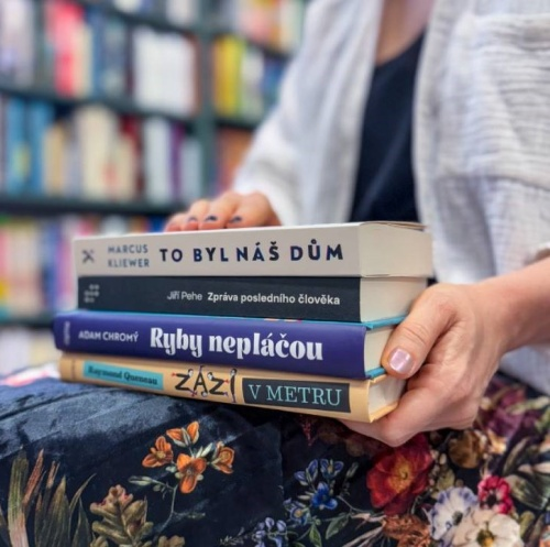 žena v knihkupectví s knihami v klíně