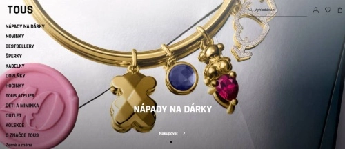 zlatý náramek a na něm přívěsek medvídka, kulička a srdce