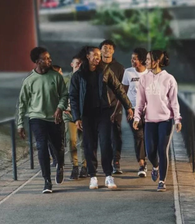 mladí lidé ve sportovním oblečení kráčející po chodníku