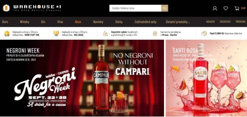 červená láhev s Campari na barovém pultu spolu se sklenicí