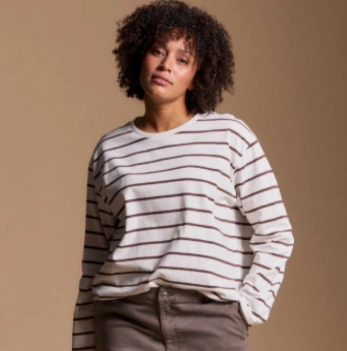 žena v bílo-hnědém svetříku a hnědých kalhotách