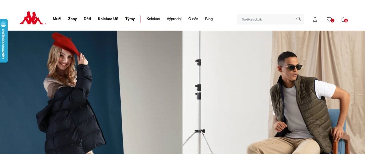 žena v černé bundě a s červenou baretkou a muž ve vestě, tričku a kalhotách sedící na židli