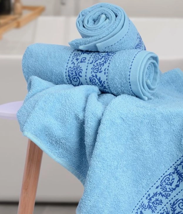 Modré ručníky na koupelně na dřevěném stolečku