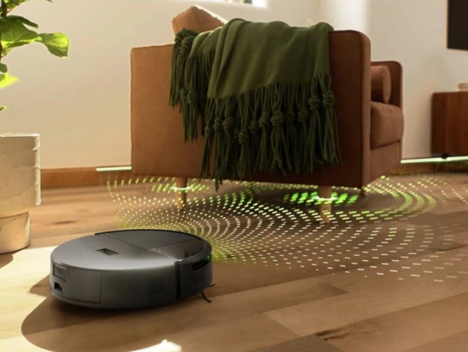 robotický vysavač v obýváku při sedačce