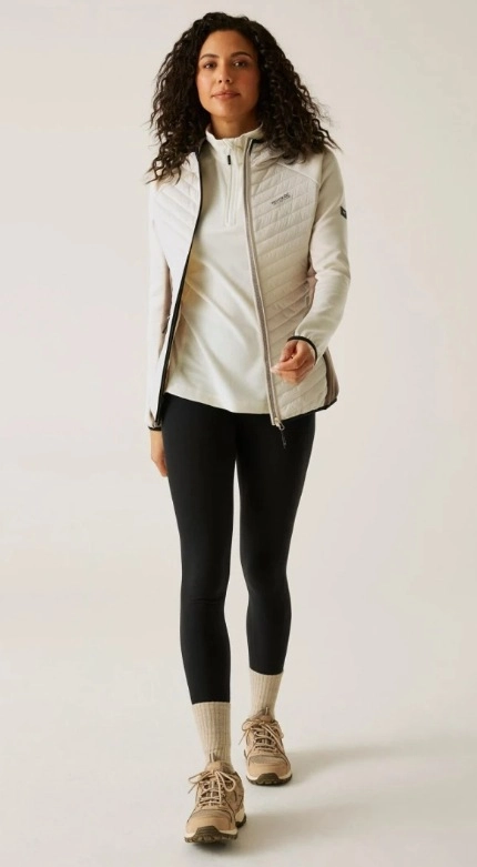 Žena ve sportovním outfitu v béžových odstínech s černými legínami