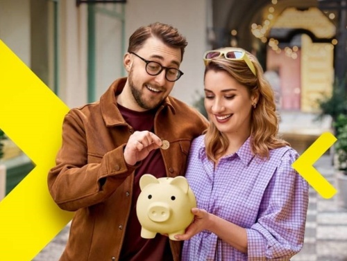 Raiffeisen Bank - žena držící spořící prasátko a muž házející minci do prasátka