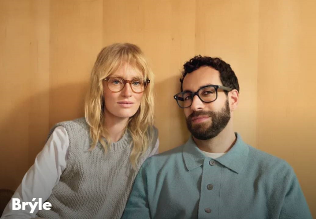 fielmann - pár v brýlích sedící před žlutou stěnou