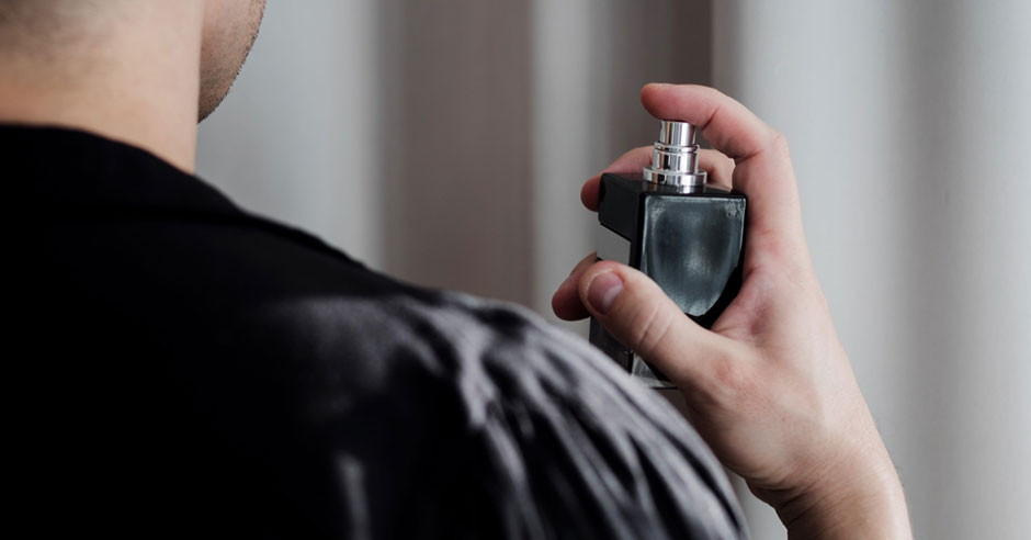  muž na sebe aplikuje parfum